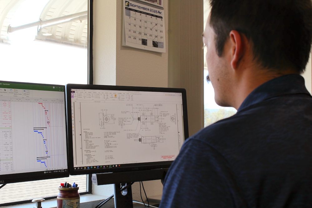 man at computer, with engineering program schematics