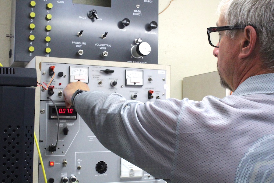 Man at testing machine turning dial